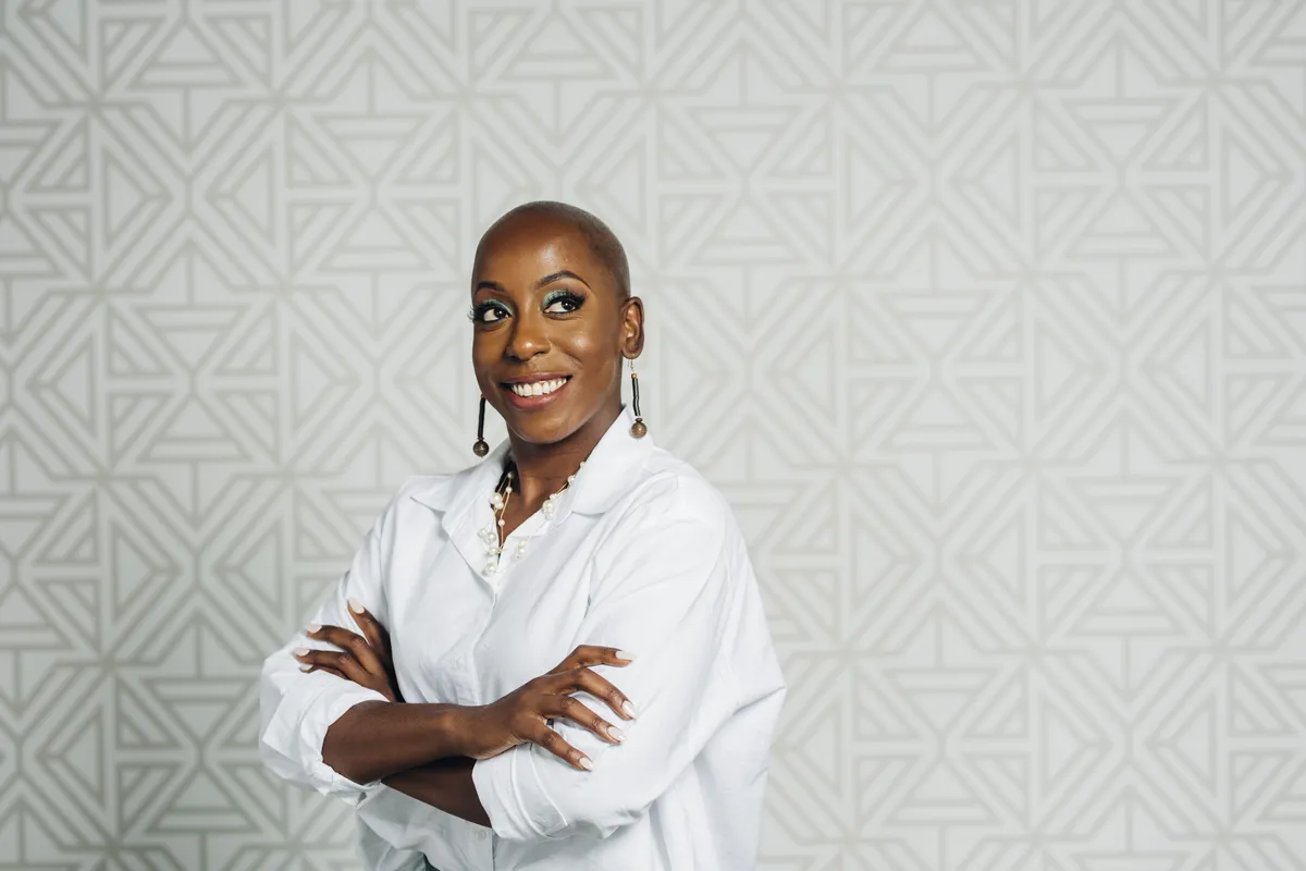 Carrolee Moore, arms crossed, smiling, in a white shirt
